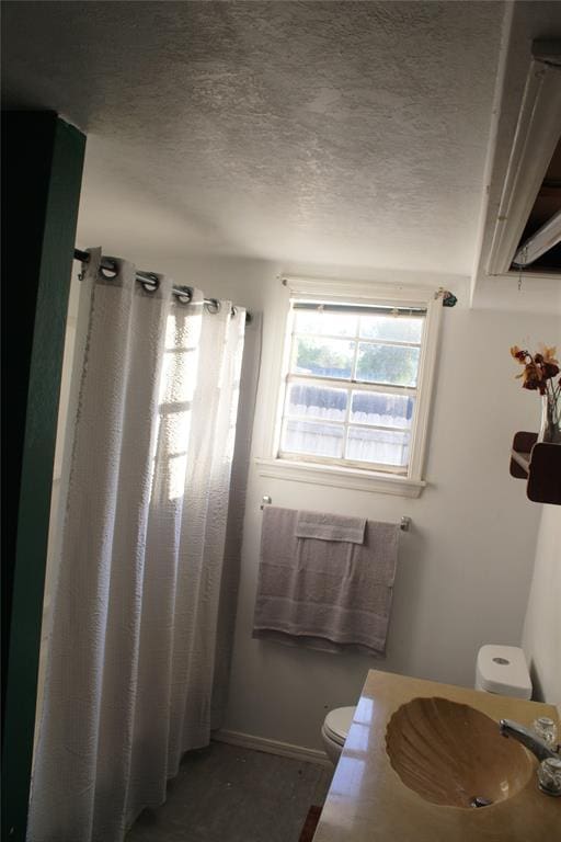 107 S 10th St, Davis, OK 73030 - bathroom with toilet, a sink, a textured ceiling, baseboards, and curtained shower