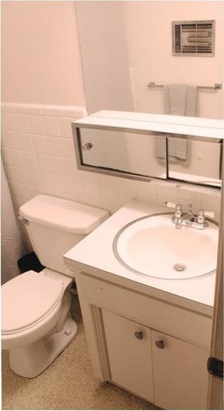 107 S 10th St, Davis, OK 73030 - bathroom with vanity, tile walls, toilet, and wainscoting