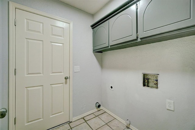 clothes washing area with cabinet space, washer hookup, electric dryer hookup, baseboards, and light tile patterned floors