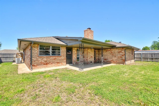 rear view of house featuring brick siding, a patio, a chimney, and a fenced backyard