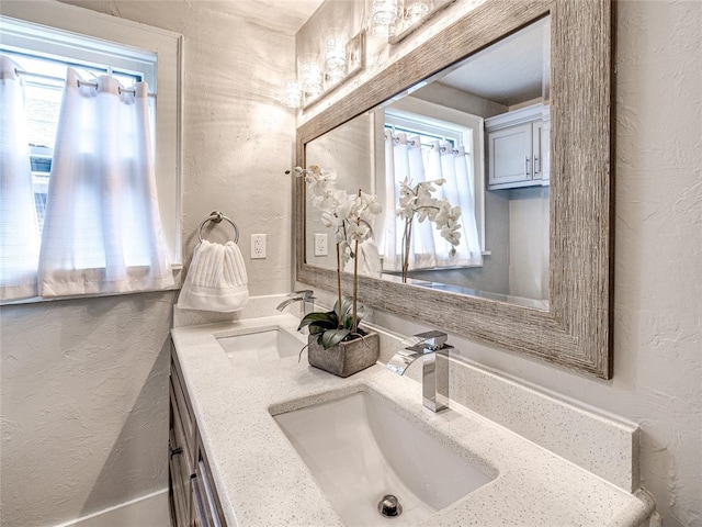 725 NE 15th St, Oklahoma City, OK 73104 - bathroom with a wealth of natural light, a textured wall, and a sink