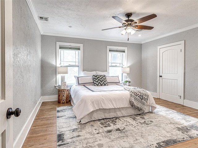 725 NE 15th St, Oklahoma City, OK 73104 - bedroom with ornamental molding, visible vents, a textured wall, and wood finished floors