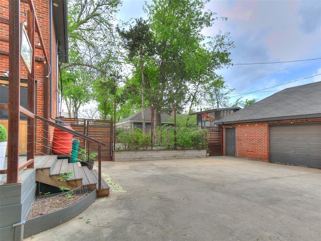 725 NE 15th St, Oklahoma City, OK 73104 - view of patio with concrete driveway and a garage