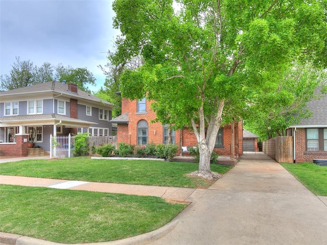 725 NE 15th St, Oklahoma City, OK 73104 - view of front facade featuring concrete driveway, a front yard, and brick siding