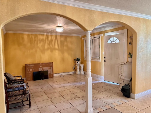 607 E Liveoak St, Altus, OK 73521 - foyer entrance featuring arched walkways, light tile patterned floors, crown molding, a textured wall, and baseboards