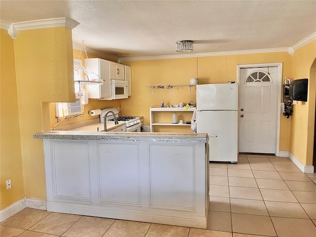 607 E Liveoak St, Altus, OK 73521 - kitchen featuring white appliances, ornamental molding, light countertops, light tile patterned flooring, and a peninsula