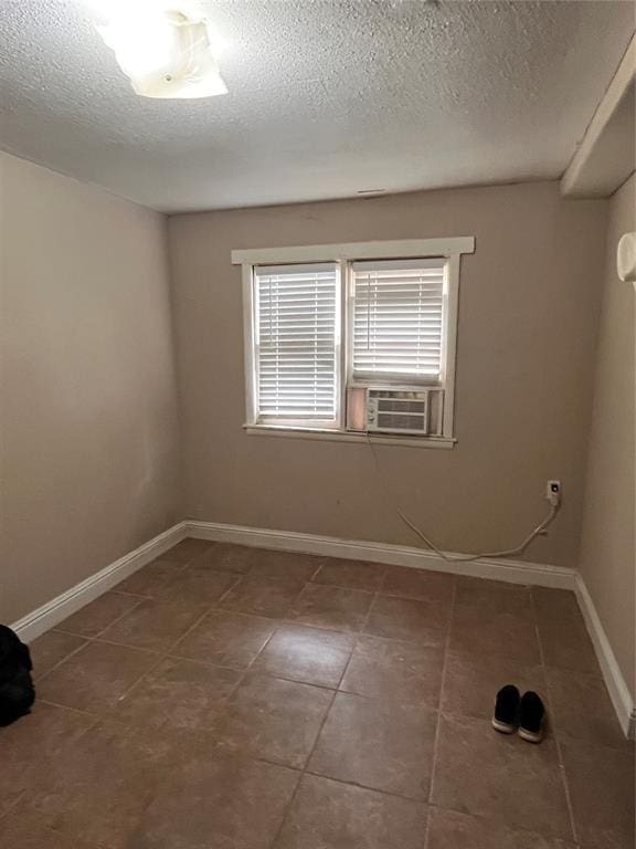 607 E Liveoak St, Altus, OK 73521 - spare room featuring tile patterned floors, a textured ceiling, and cooling unit