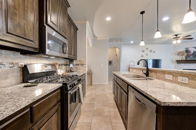 15808 Cantera Creek Dr, Edmond, OK 73013 - kitchen with arched walkways, appliances with stainless steel finishes, backsplash, a sink, and crown molding