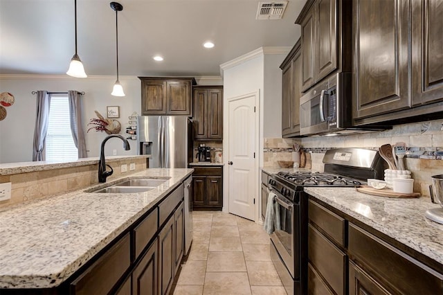 15808 Cantera Creek Dr, Edmond, OK 73013 - kitchen with tasteful backsplash, stainless steel appliances, ornamental molding, a sink, and visible vents