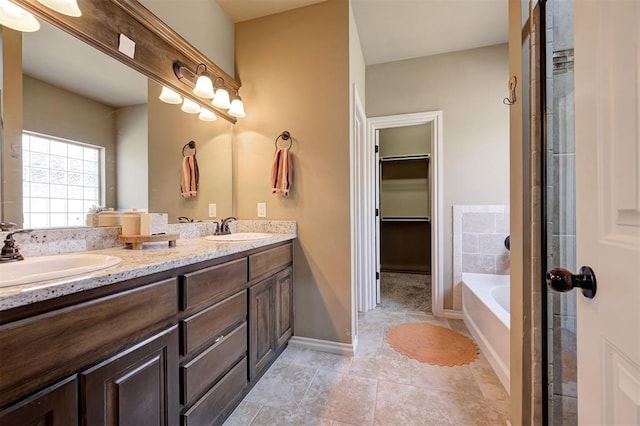 15808 Cantera Creek Dr, Edmond, OK 73013 - bathroom with tile patterned floors, a garden tub, double vanity, and a sink