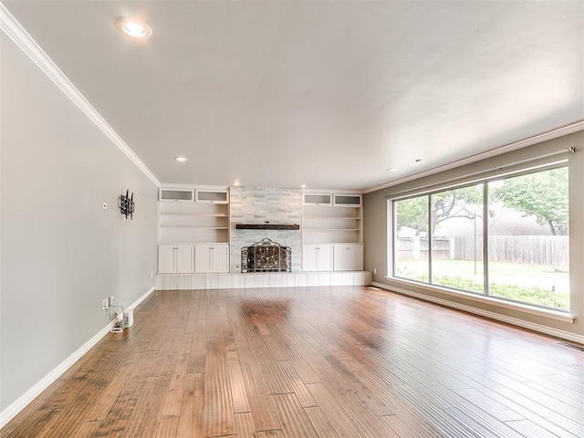 12112 Blue Sage Rd, Oklahoma City, OK 73120 - unfurnished living room with built in shelves, a large fireplace, baseboards, ornamental molding, and hardwood / wood-style flooring