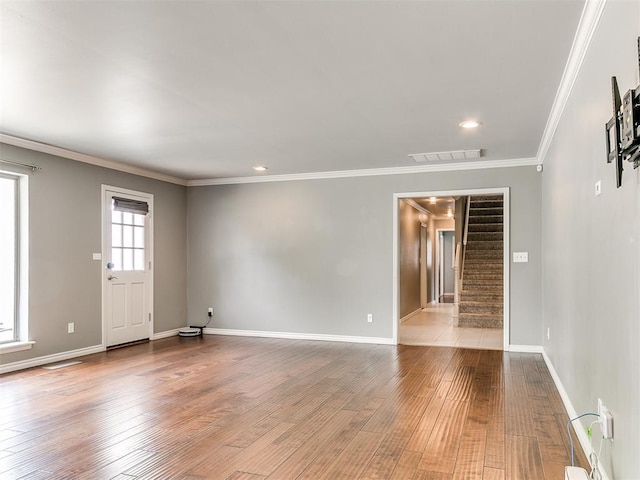 12112 Blue Sage Rd, Oklahoma City, OK 73120 - empty room with visible vents, ornamental molding, stairs, wood finished floors, and baseboards