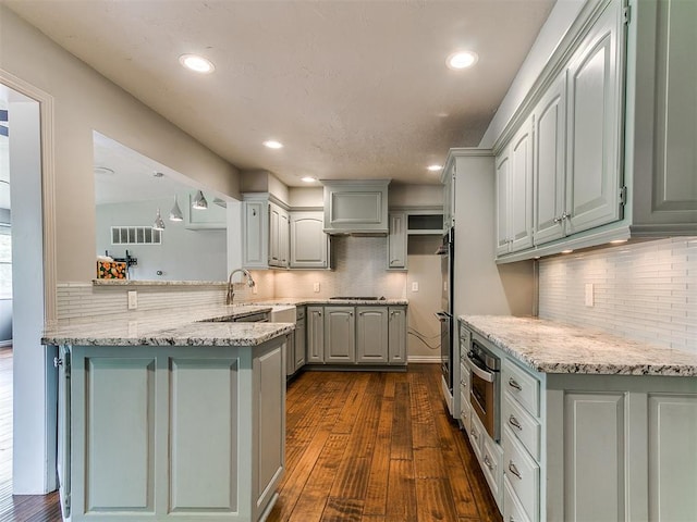 12112 Blue Sage Rd, Oklahoma City, OK 73120 - kitchen featuring a peninsula, appliances with stainless steel finishes, decorative backsplash, and gray cabinets