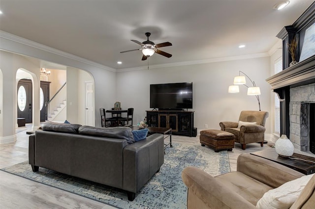 2051 Vaquero Ct, Edmond, OK 73034 - living area featuring arched walkways, wood finished floors, stairs, ceiling fan, and crown molding