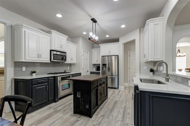 2051 Vaquero Ct, Edmond, OK 73034 - kitchen featuring a sink, a chandelier, dark cabinetry, white cabinetry, and appliances with stainless steel finishes