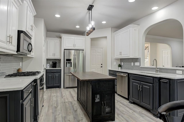 2051 Vaquero Ct, Edmond, OK 73034 - kitchen with white cabinetry, a sink, backsplash, and appliances with stainless steel finishes