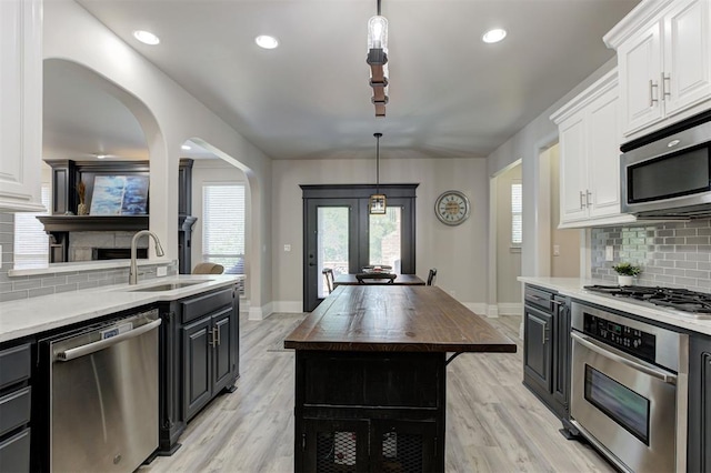 2051 Vaquero Ct, Edmond, OK 73034 - kitchen with white cabinets, stainless steel appliances, baseboards, and a sink