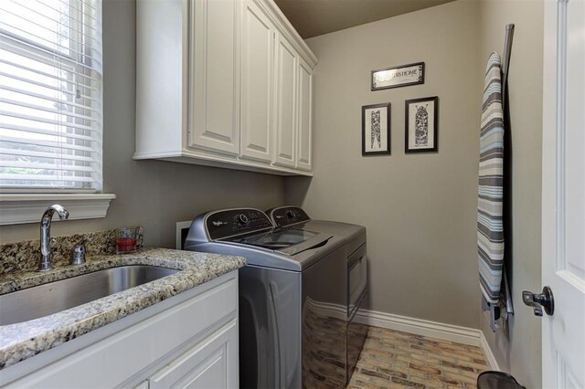 2051 Vaquero Ct, Edmond, OK 73034 - washroom with washing machine and clothes dryer, a sink, brick floor, cabinet space, and baseboards