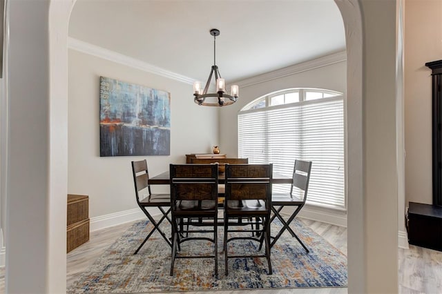 2051 Vaquero Ct, Edmond, OK 73034 - dining space featuring arched walkways, ornamental molding, wood finished floors, and a chandelier