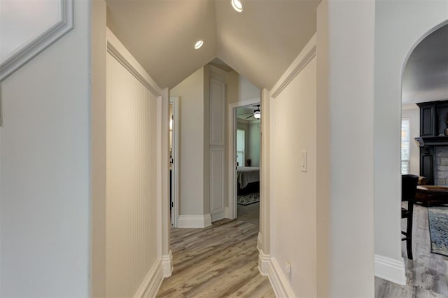 2051 Vaquero Ct, Edmond, OK 73034 - corridor featuring light wood-style flooring, baseboards, arched walkways, and vaulted ceiling