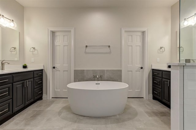 2051 Vaquero Ct, Edmond, OK 73034 - bathroom featuring a freestanding bath, tile walls, tile patterned floors, and vanity