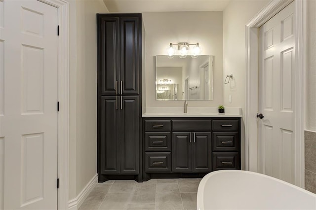 2051 Vaquero Ct, Edmond, OK 73034 - bathroom with tile patterned floors, baseboards, vanity, and a freestanding bath