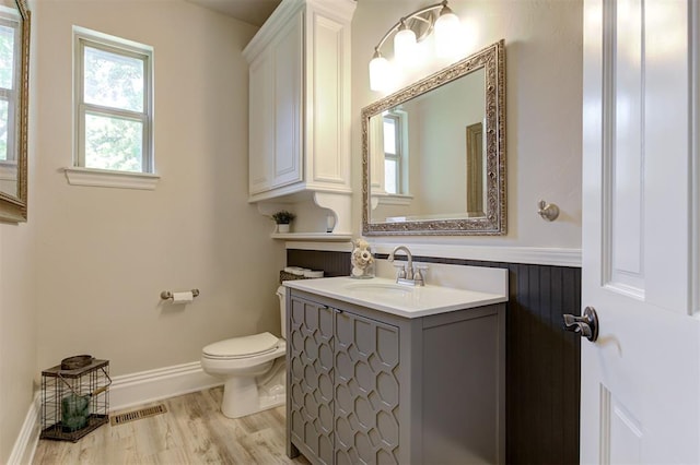 2051 Vaquero Ct, Edmond, OK 73034 - half bath with toilet, vanity, wood finished floors, and visible vents