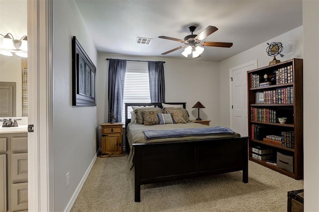 2051 Vaquero Ct, Edmond, OK 73034 - bedroom with a sink, ensuite bathroom, baseboards, visible vents, and light colored carpet