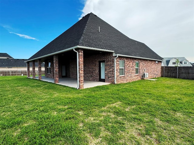 back of property with central AC unit, a fenced backyard, a patio, a lawn, and brick siding
