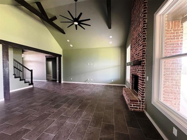 unfurnished living room featuring high vaulted ceiling, stairway, ceiling fan, beamed ceiling, and a fireplace