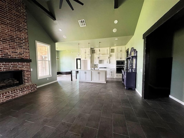 living area with visible vents, beam ceiling, baseboards, high vaulted ceiling, and ceiling fan