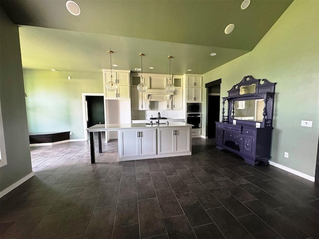 kitchen with white cabinets, built in microwave, recessed lighting, an island with sink, and stainless steel oven