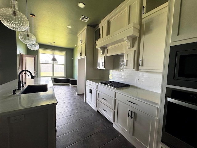 kitchen with a sink, built in microwave, oven, gas stovetop, and visible vents