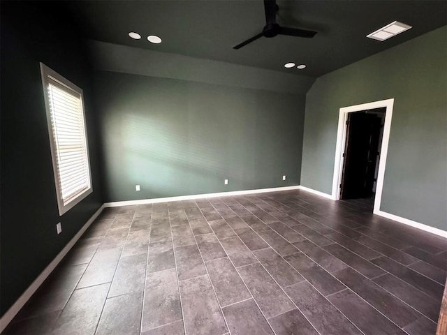 unfurnished room featuring recessed lighting, lofted ceiling, baseboards, dark tile patterned flooring, and ceiling fan