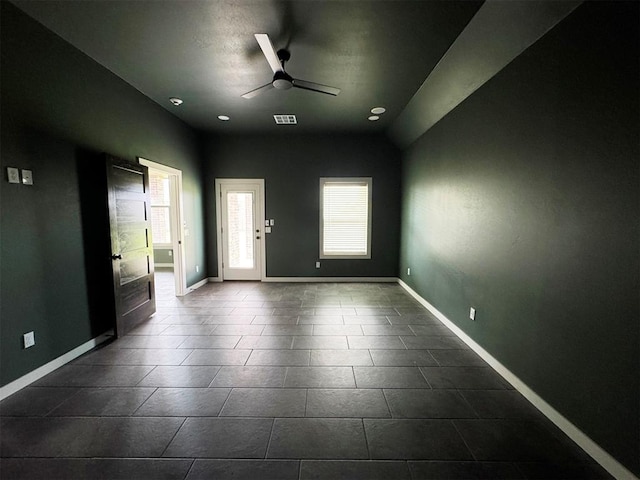 entryway featuring baseboards, dark tile patterned flooring, visible vents, and ceiling fan