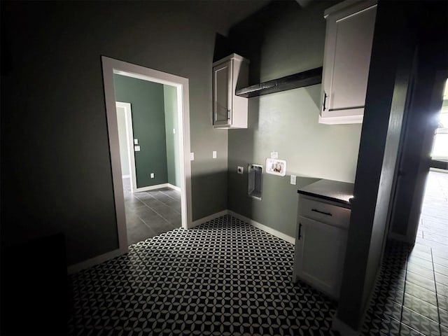washroom featuring cabinet space, hookup for a washing machine, baseboards, and hookup for an electric dryer