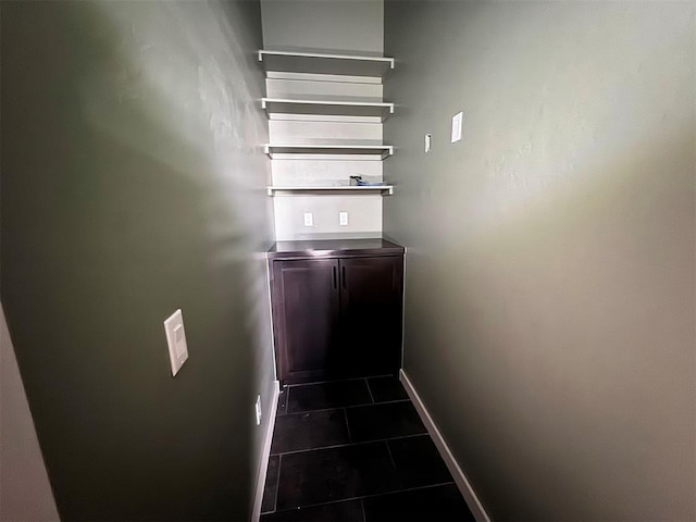 stairway featuring baseboards and tile patterned flooring