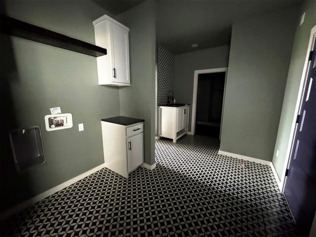 washroom with dark floors, baseboards, laundry area, and washer hookup