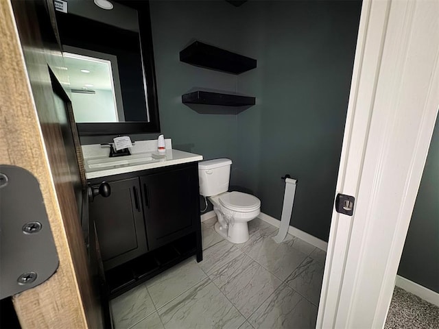 bathroom featuring marble finish floor, vanity, toilet, and baseboards