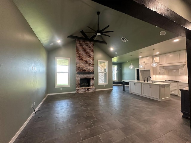 4140 Peony Cir, Piedmont, OK 73078 - unfurnished living room with ceiling fan, high vaulted ceiling, a brick fireplace, beamed ceiling, and recessed lighting