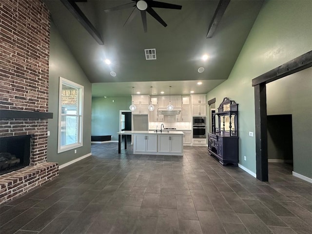 4140 Peony Cir, Piedmont, OK 73078 - kitchen with appliances with stainless steel finishes, high vaulted ceiling, a ceiling fan, white cabinetry, and a brick fireplace