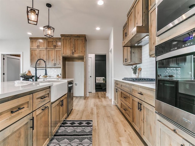 kitchen featuring a sink, decorative light fixtures, appliances with stainless steel finishes, decorative backsplash, and recessed lighting