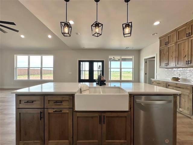 kitchen with a ceiling fan, light wood-style flooring, dishwasher, a sink, and open floor plan