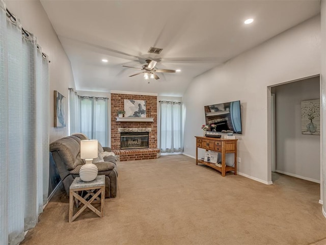 living area featuring a brick fireplace, a ceiling fan, visible vents, and carpet