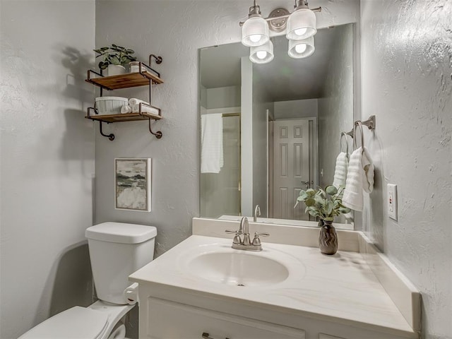 full bath with toilet, an enclosed shower, a textured wall, and vanity