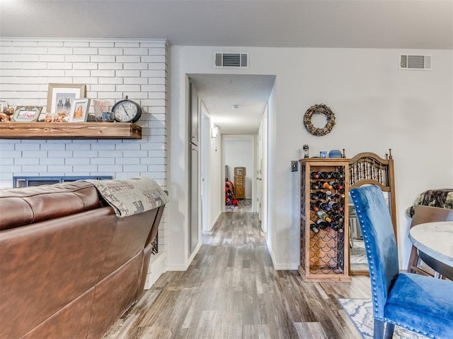 corridor featuring baseboards, visible vents, and wood finished floors