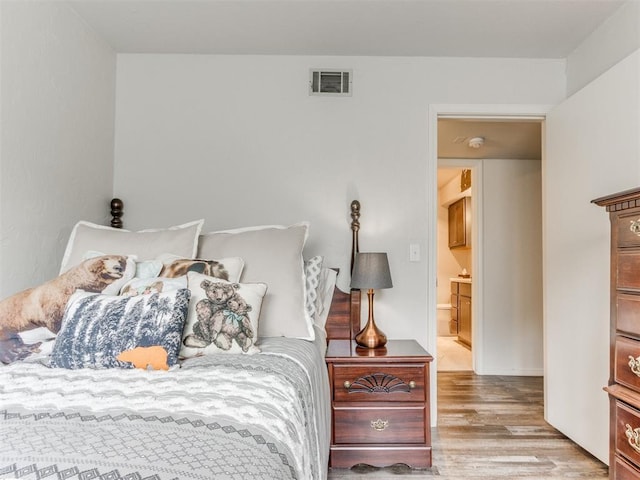 bedroom featuring visible vents and wood finished floors