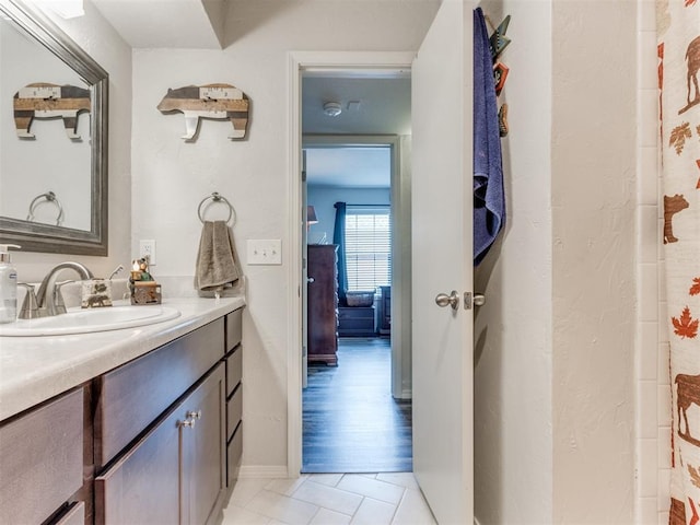 bathroom with vanity, baseboards, and tile patterned floors