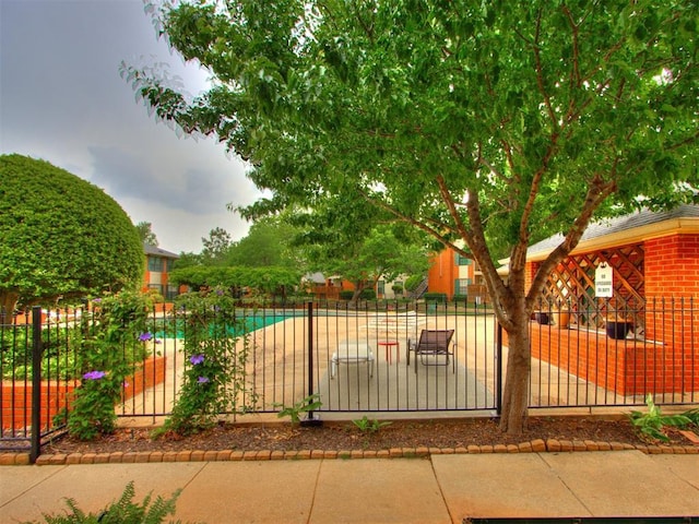 view of gate featuring a community pool and fence