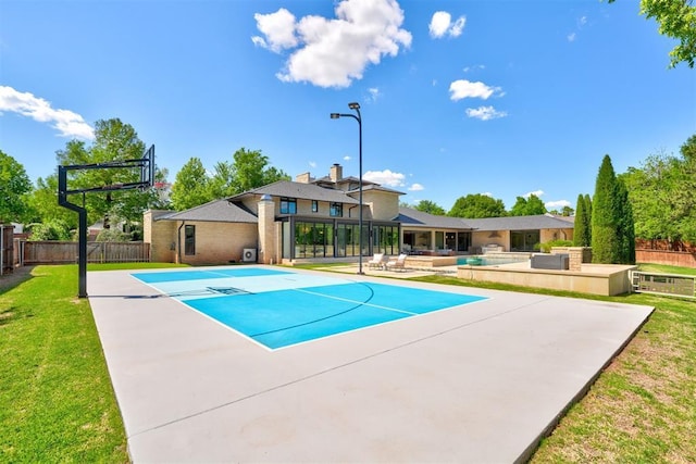 view of swimming pool featuring a yard, fence, and community basketball court